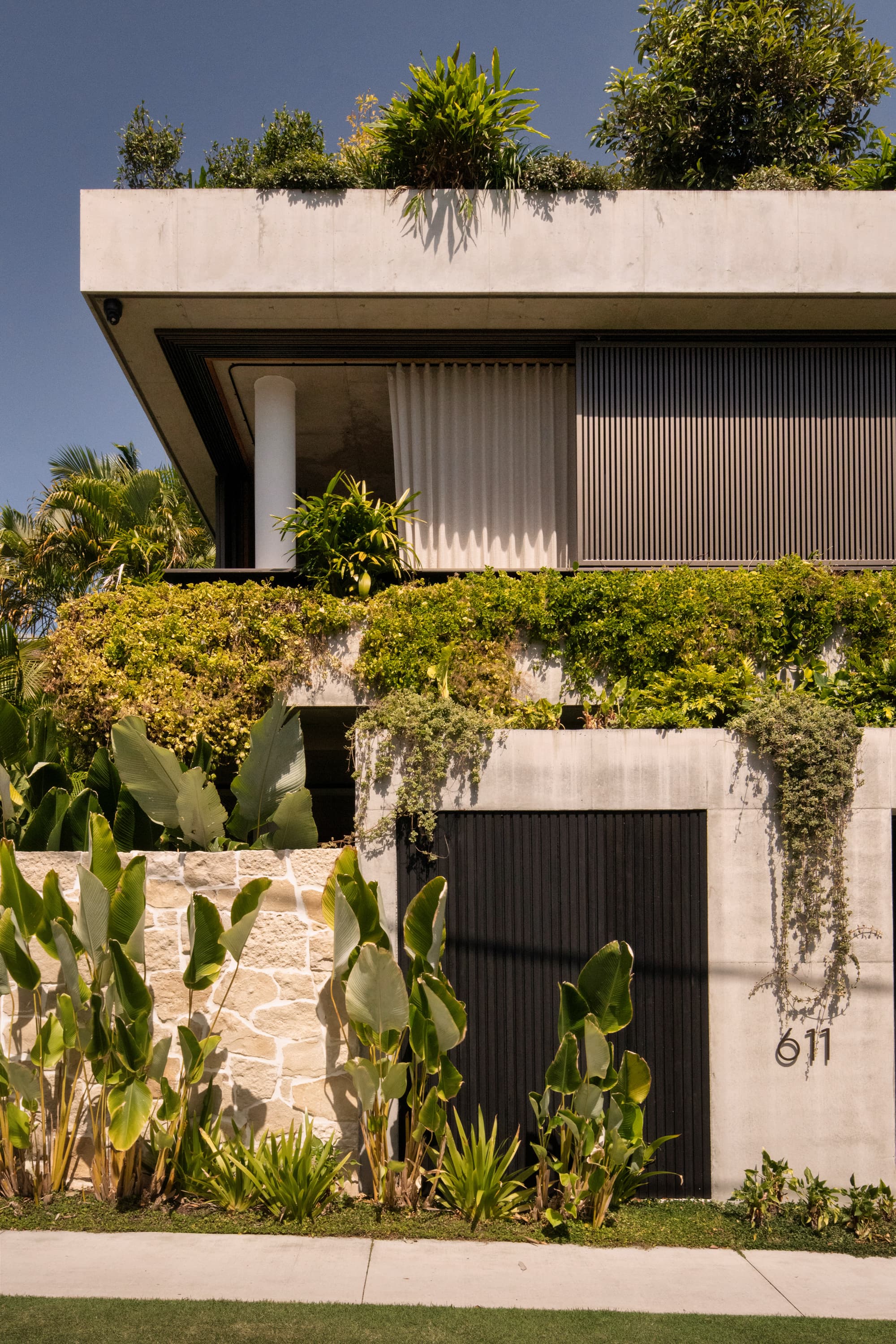 Concrete and stone residence framed by tropical landscaping